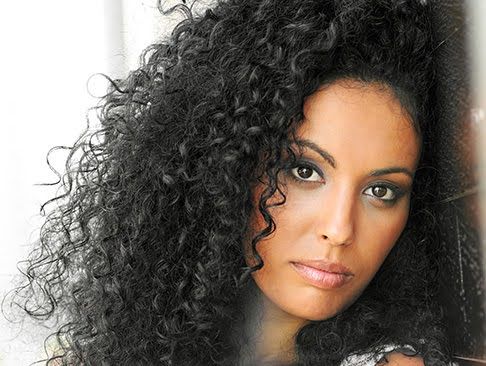 Woman with curly hair and captivating expression.