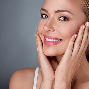 Smiling woman with glowing skin and healthy complexion.