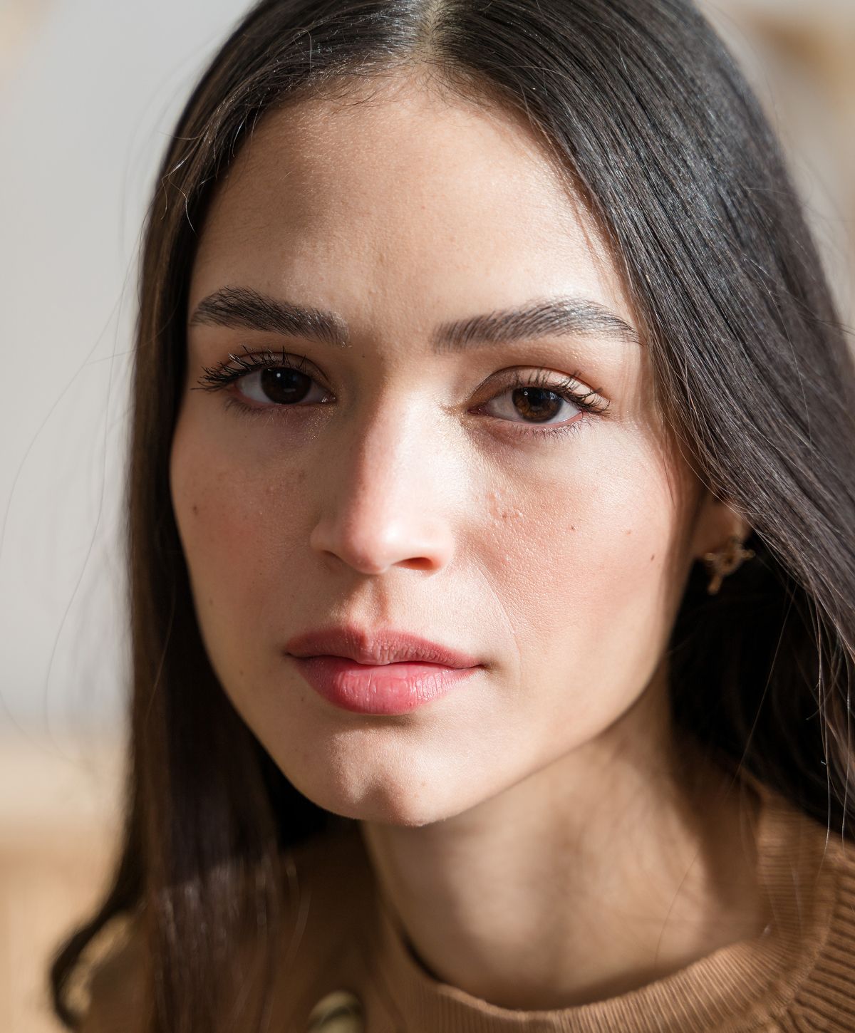 Young woman with long, wavy hair smiling gently.