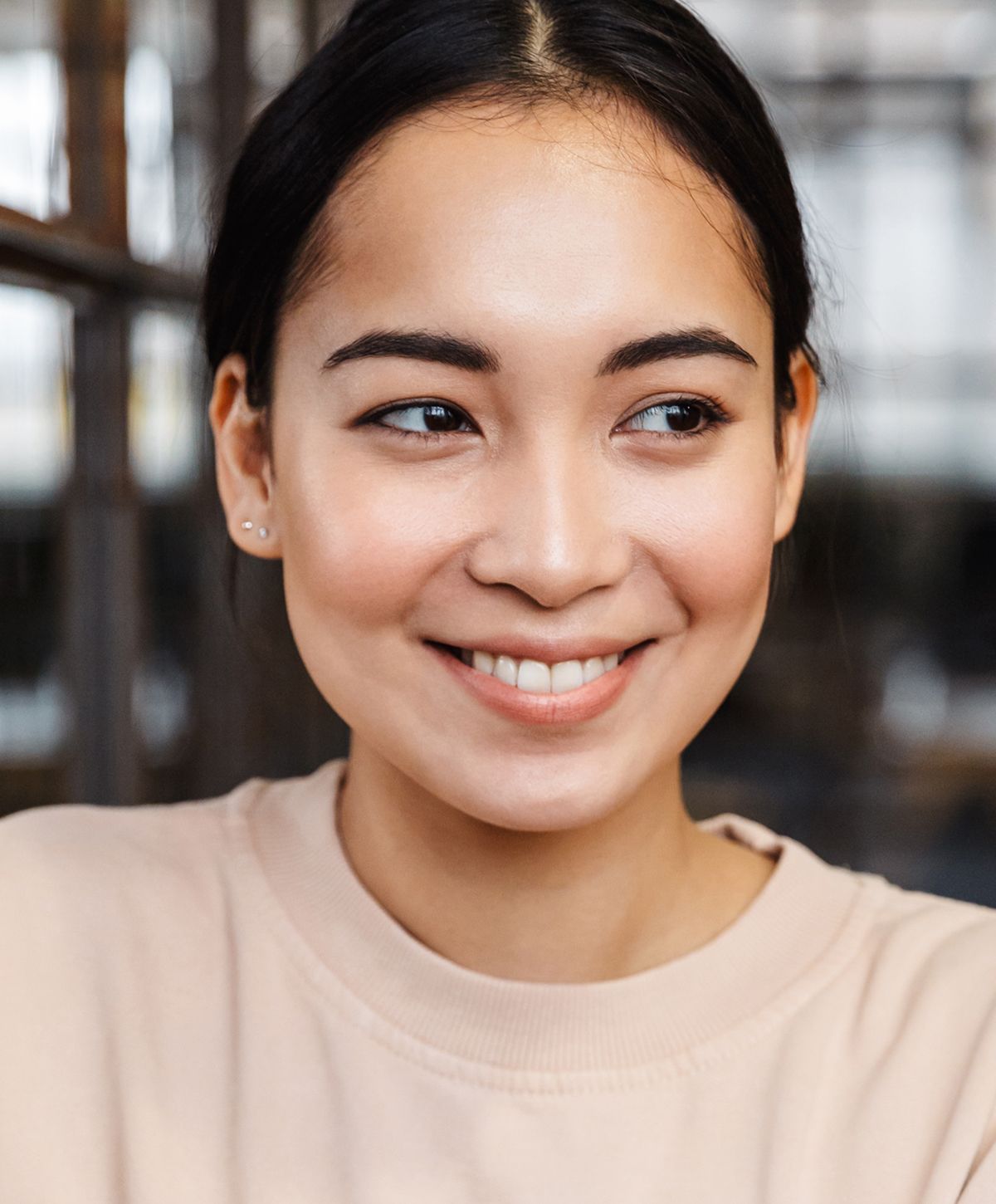 Smiling woman in casual attire indoors.