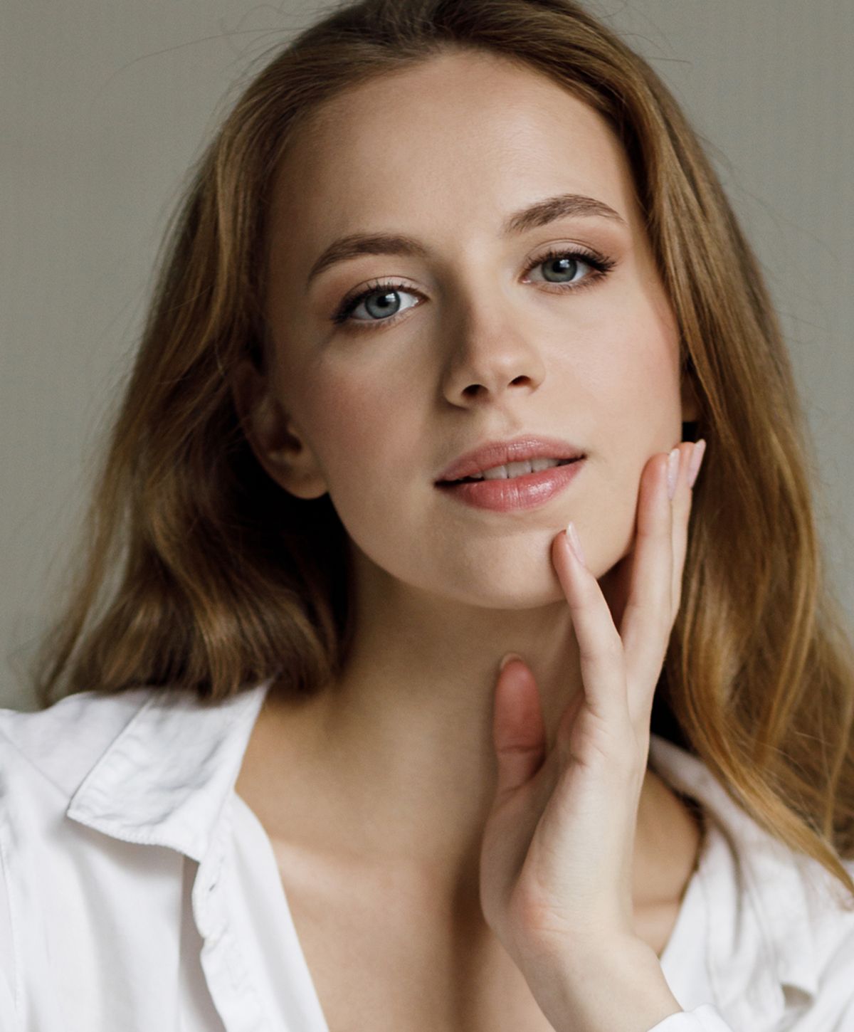 Young woman with long, wavy hair smiling gently.