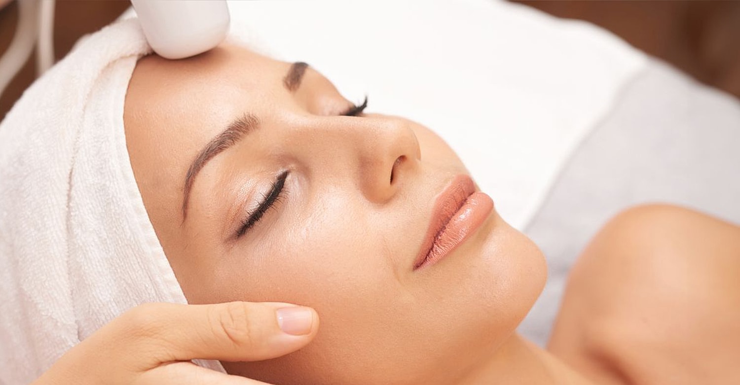 Woman receiving facial treatment in a spa.