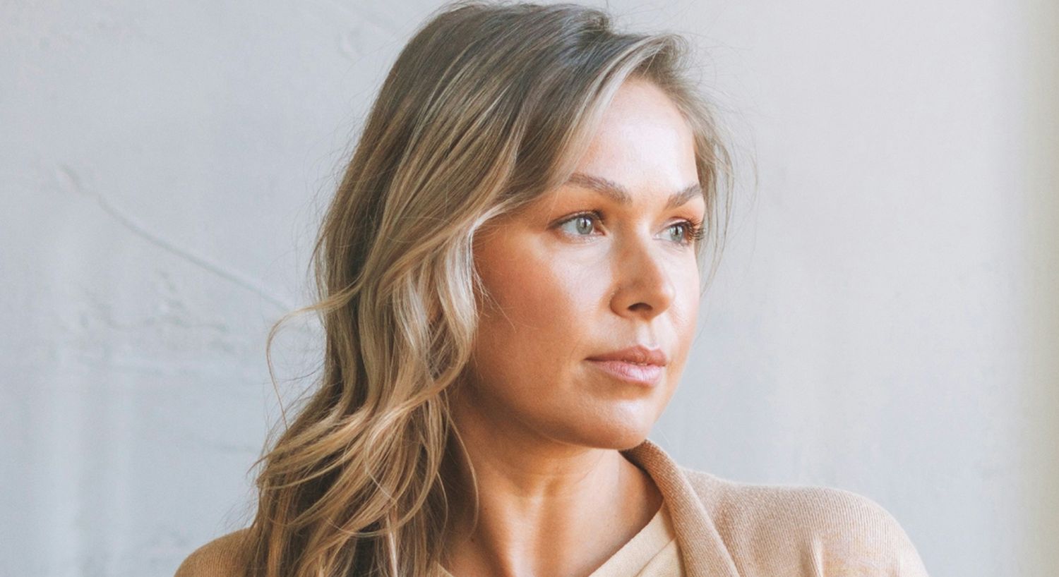 Woman with long hair looking thoughtfully away.