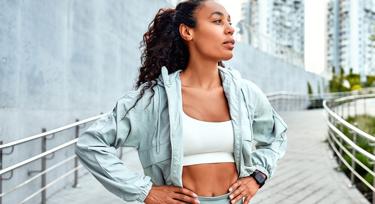 Athletic woman standing outdoors in activewear.