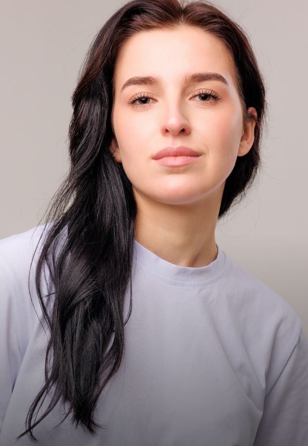 Young woman with long dark hair, neutral expression.