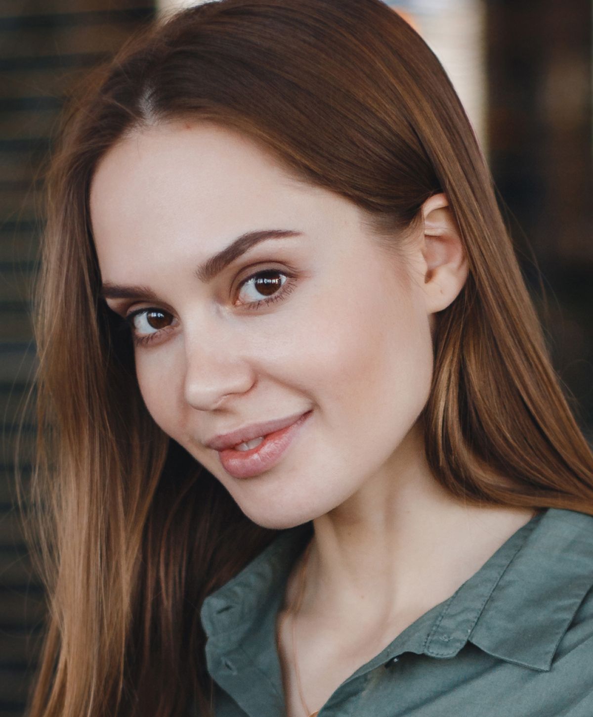 Young woman smiling with long brown hair.