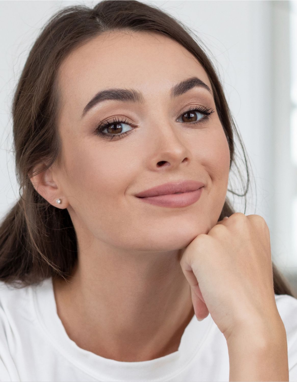 Smiling woman resting her chin on hand.