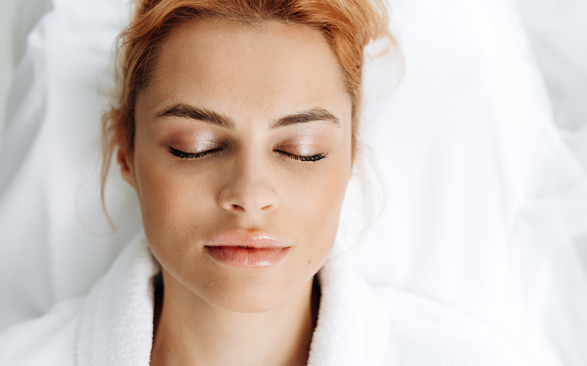 Woman relaxing with eyes closed, soft expression.