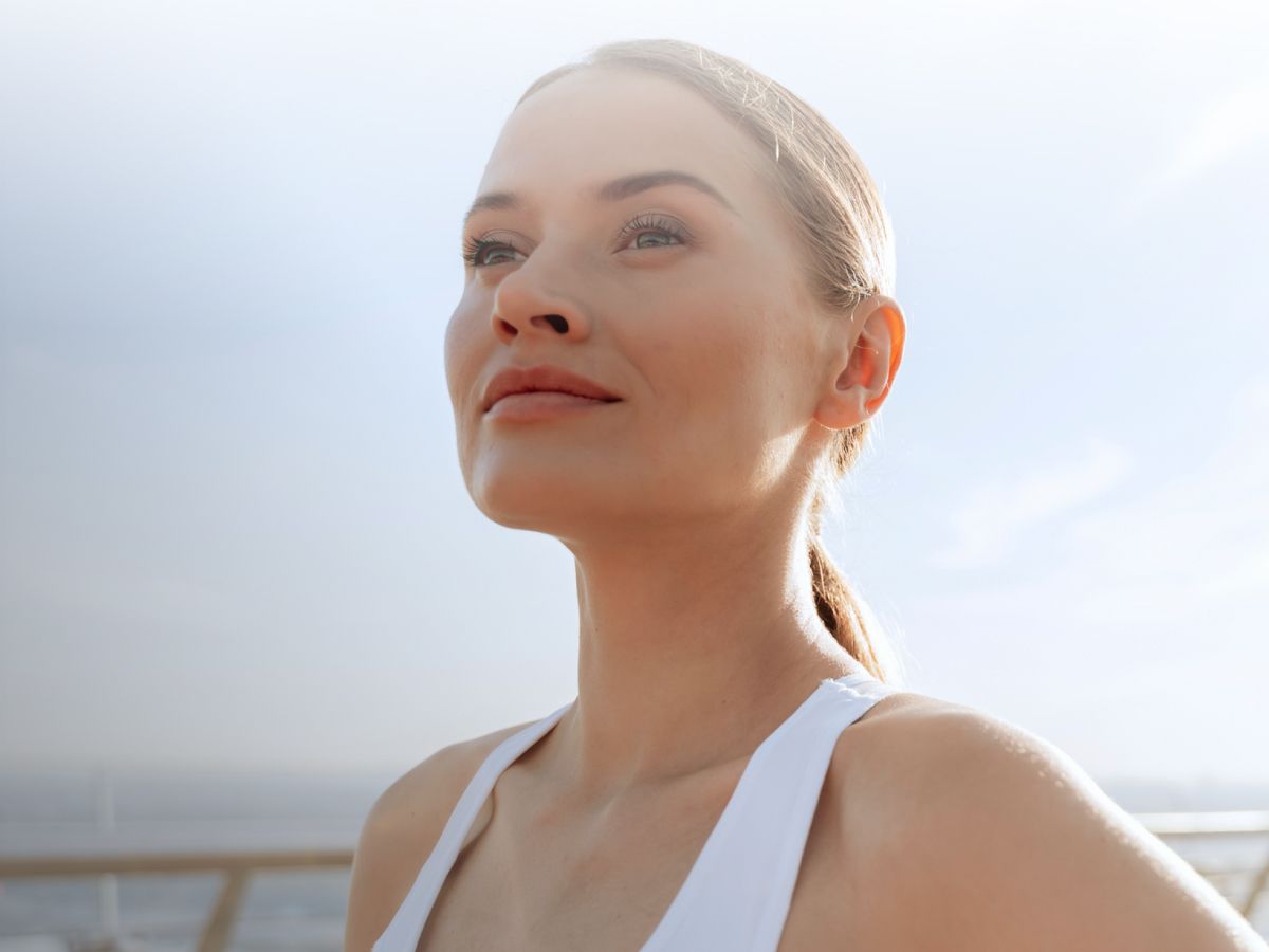Woman enjoying the outdoors with a serene expression.